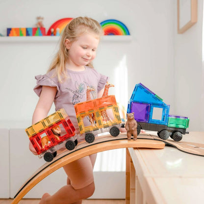 Mädchen spielt mit den Magnetbausteinen und hat einen Zug gebaut mit Tieren drin