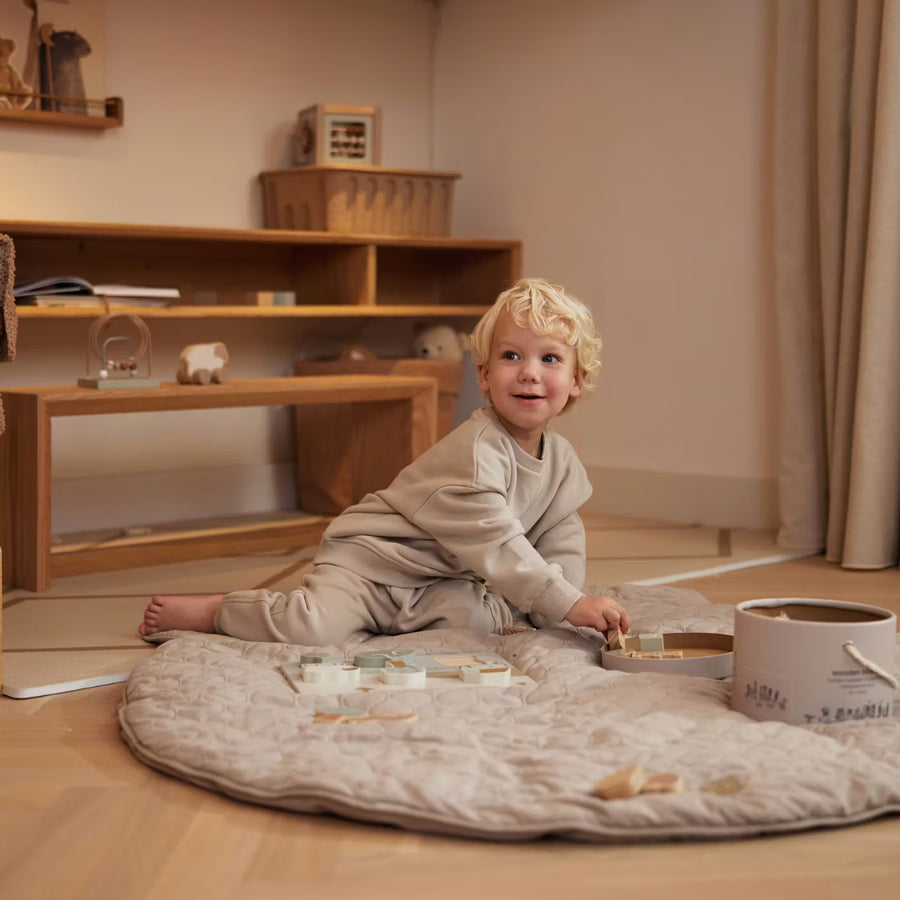 Kleinkind spielt mit dem Holzpuzzle von Jollein