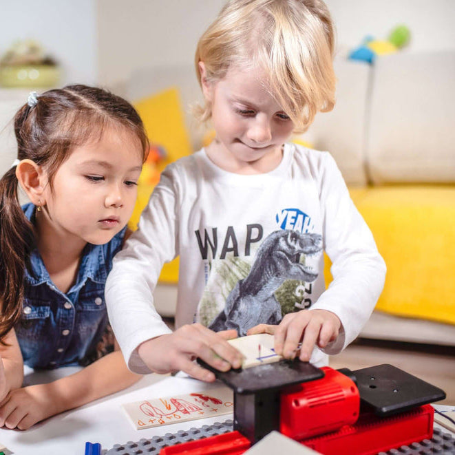 Zwei Kinder arbeiten an der Playmake Stichsäge für Kinder und schneidet etwas aus Holz aus