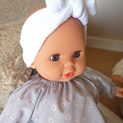 Puppe Daisy hat blaue Augen und trägt ein weißes Stirnband