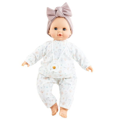 Puppe Liv hat blaue Augen und leichte Sommersprossen und trägt ein schlichtes Puppenoutfit mit Pulli und Hose sowie ein fliederfarbenes Stirnband. 