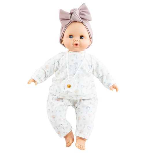 Puppe Liv hat blaue Augen und leichte Sommersprossen und trägt ein schlichtes Puppenoutfit mit Pulli und Hose sowie ein fliederfarbenes Stirnband. 