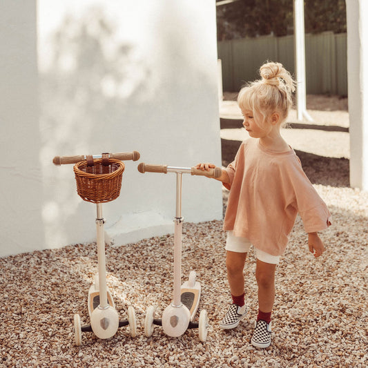 Mädchen mit zwei Roller von banwood in der Farbe creme und rosa