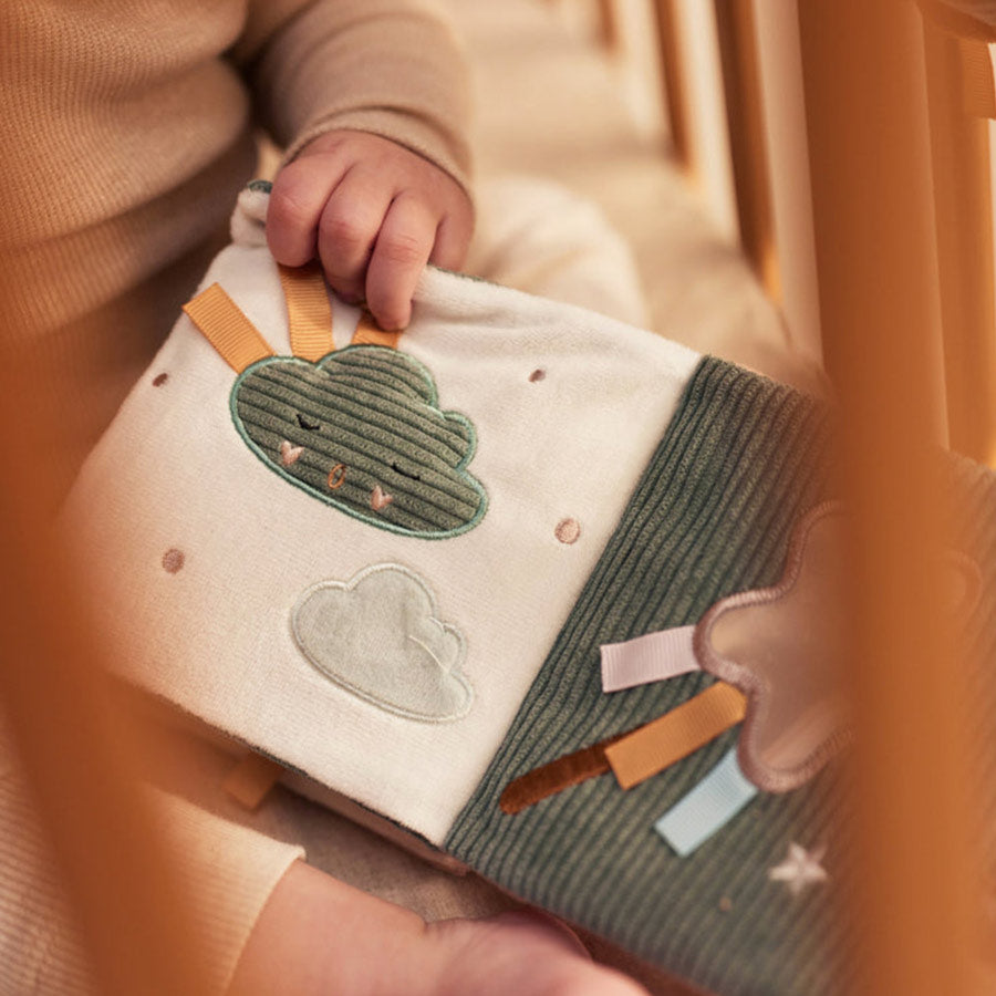 Baby spielt mit dem Stoffbuch und entdeckt die Stoffseiten
