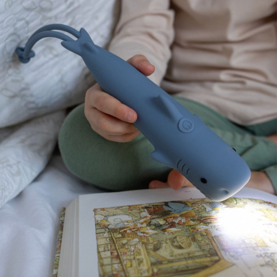 Kind entdeckt ein Buch mit der Taschenlampe Hai von Rabbit & Friends